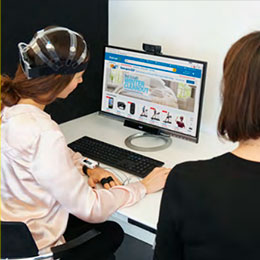 User research participant wearing an EEG headset at a screen during a testing session.