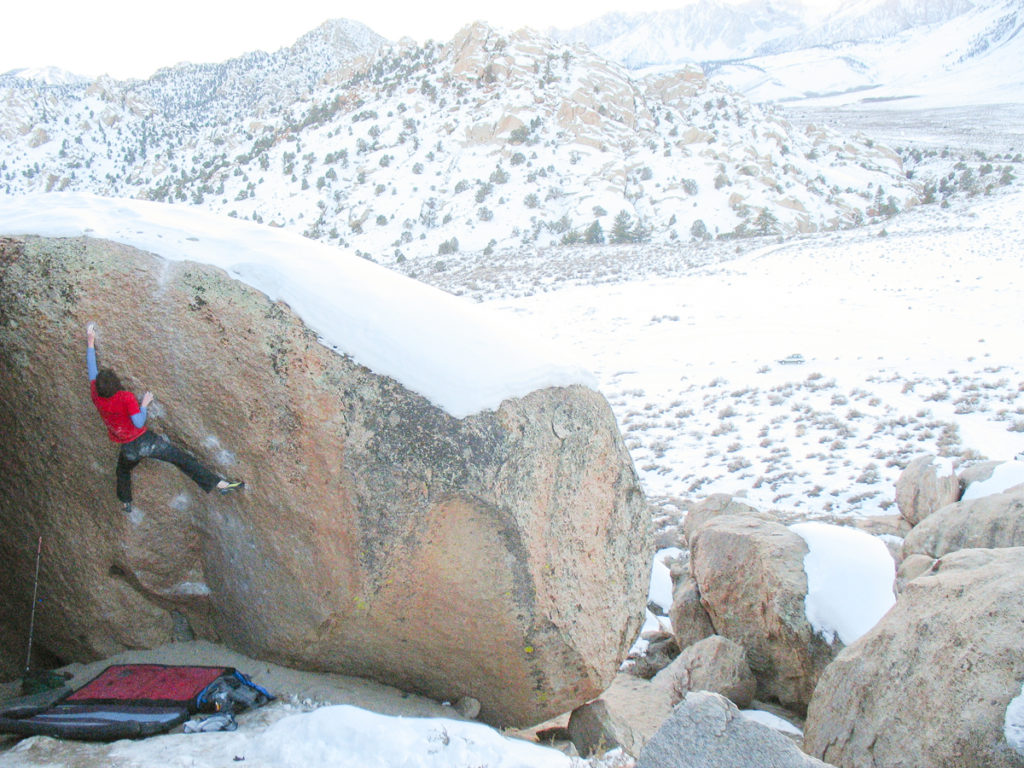 A photo of Steve climbing a boulder in what looks like a desert